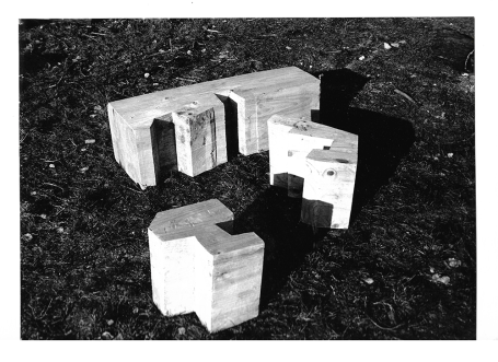 Vier weiße, geometrische Blockstrukturen auf einem dunklen Untergrund.