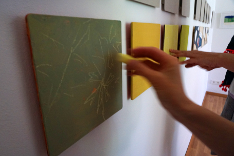 Eine Hand, die mit einem Marker auf einer grünen Wandtafel Zeichnungen macht.