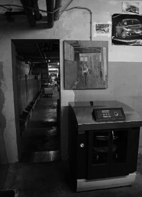Dunkler Flur mit einem Waschautomaten und Spiegel an der Wand.